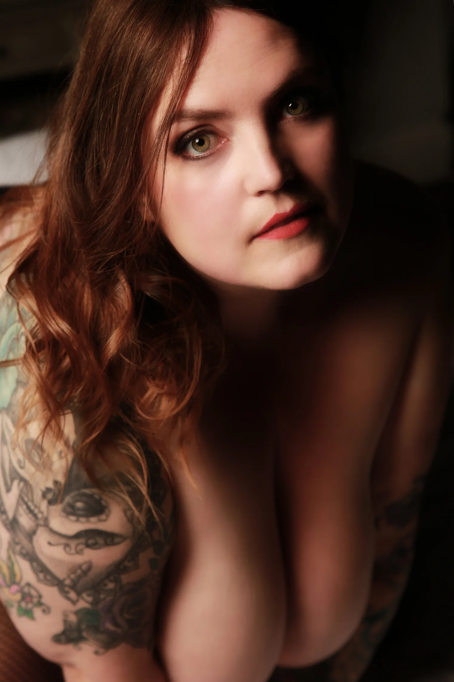 The same client in a close portrait with her red hair and tattooed shoulder visible